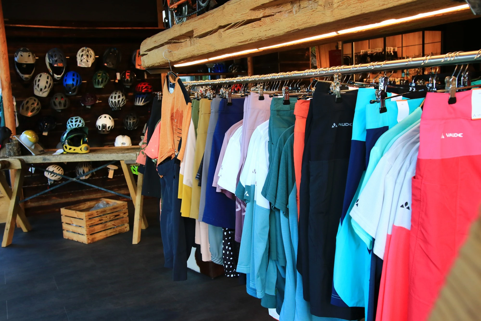 Fahrradladen mit Helmen, Kleidung und Ausr&uuml;stung an W&auml;nden und St&auml;ndern.