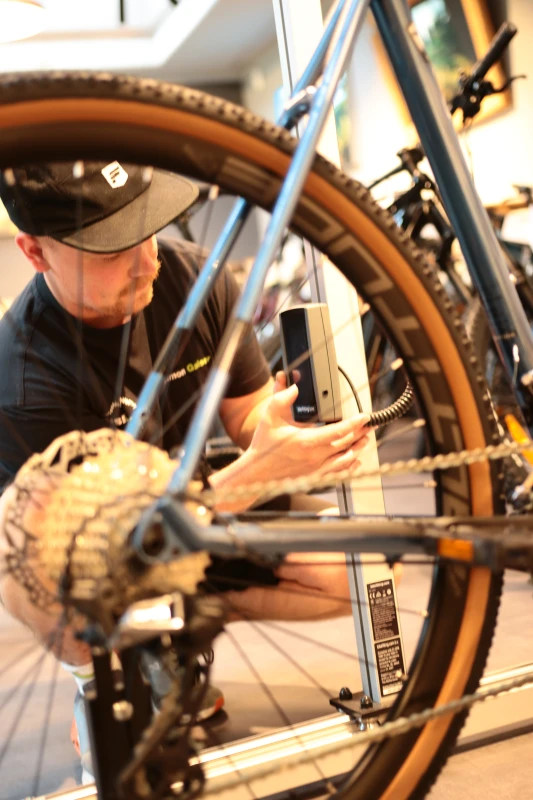 Mechaniker arbeitet an Fahrradkette und Schaltwerk w&auml;hrend einer Reparatur.