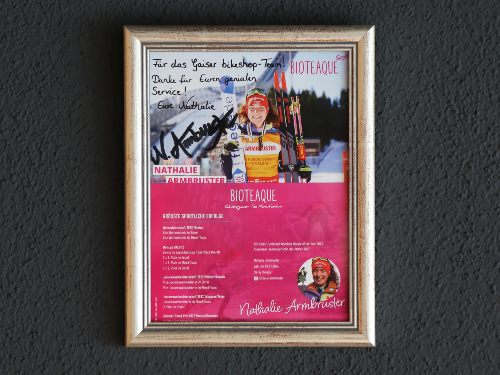 Gerahmtes signiertes Poster einer Biathletin mit handschriftlichem Widmungstext.