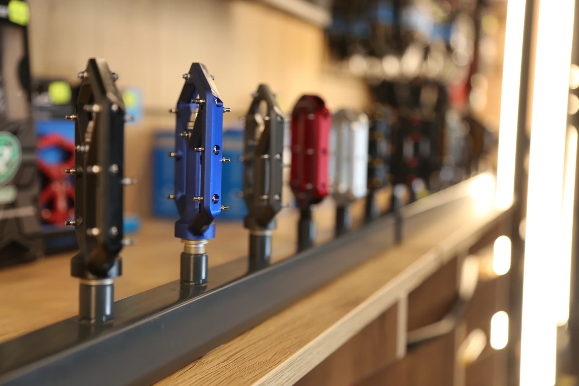 Reihe von Fahrradpedalen in verschiedenen Farben auf einer Auslagefl&auml;che im Gaiser Bikeshop.