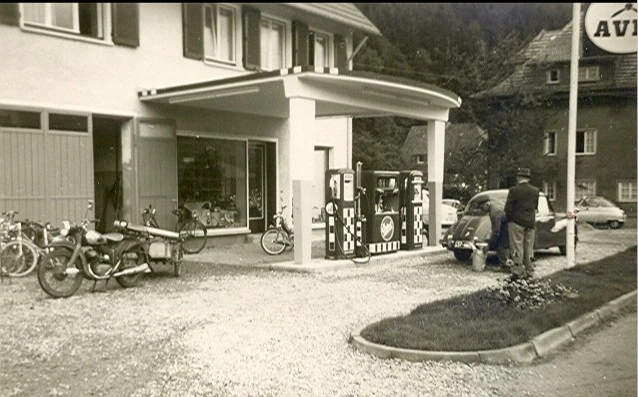 Historisches Schwarzwei&szlig;-Foto des Gaiser Bikeshop mit Fahrr&auml;dern und Motorroller vor dem Gesch&auml;ft.