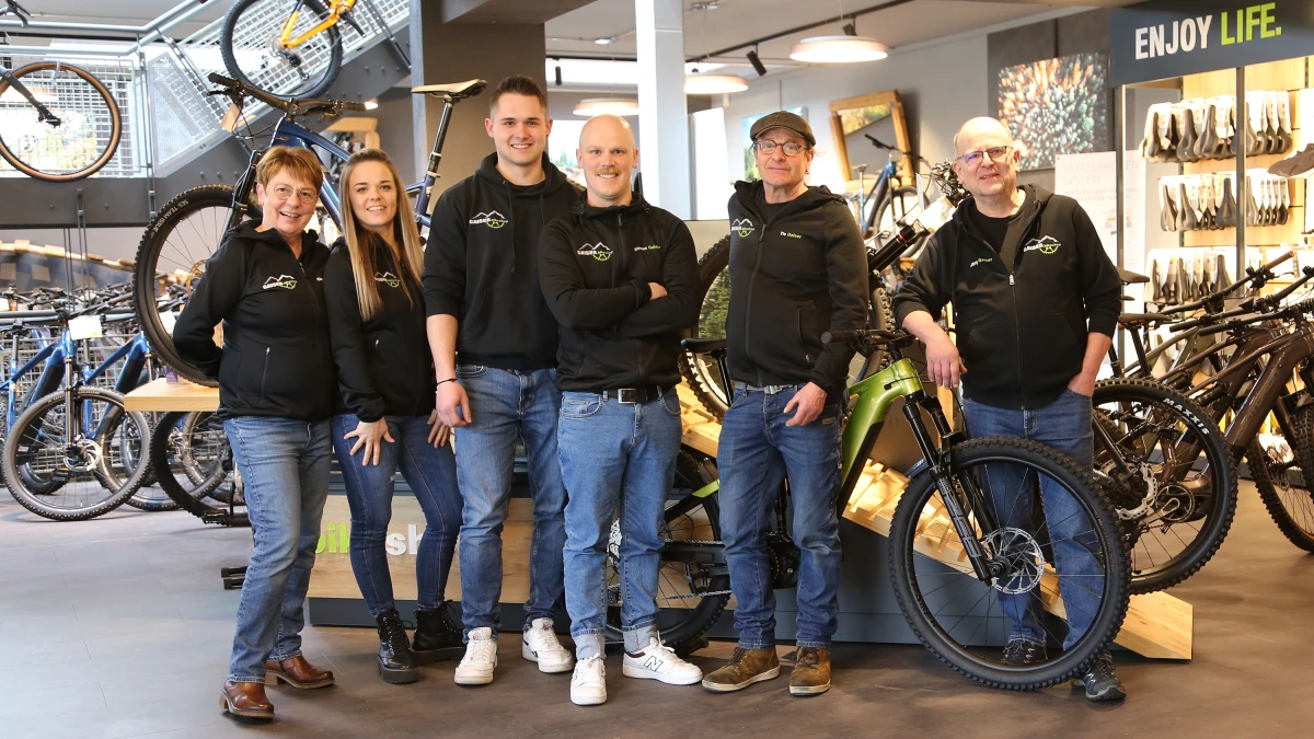 Das Team des Gaiser bikeshop posiert gemeinsam in der Filiale zwischen Fahrr&auml;dern und Zubeh&ouml;r.